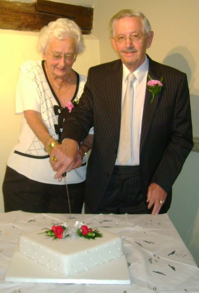 Ruth and Bill Chandler cutting their celebration cake